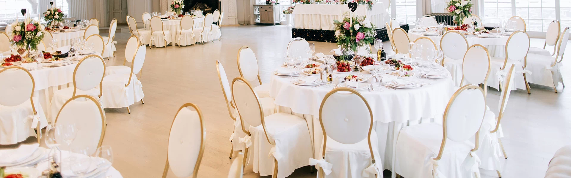 stoły zastawione i krzesła w białym kolorze ślubne